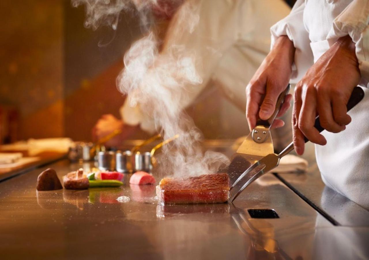 Imperial Hotel Tóquio Exterior foto A chef seasoning a steak